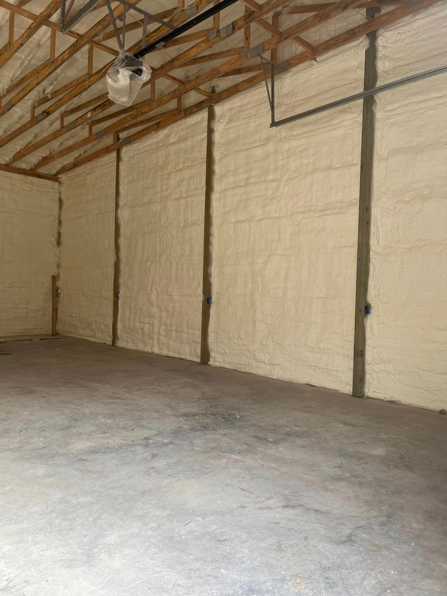 An empty garage with foam insulation on walls and ceiling.