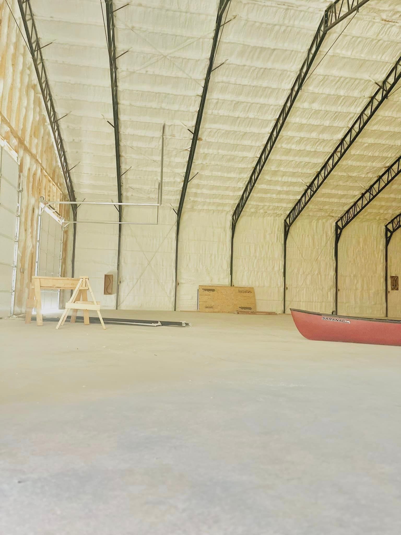 An empty warehouse with a canoe in the middle.