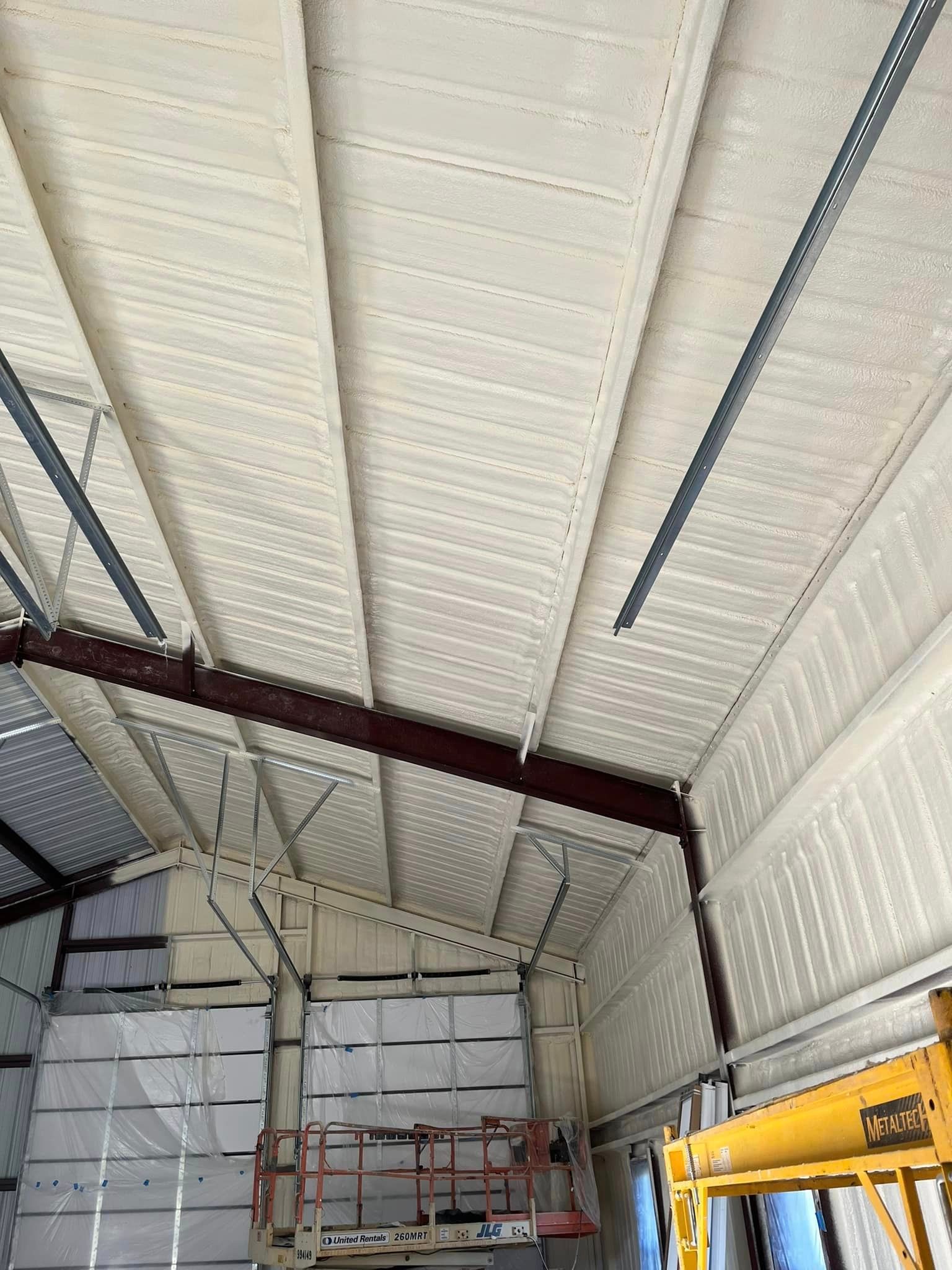 A large building with a ceiling being painted white.